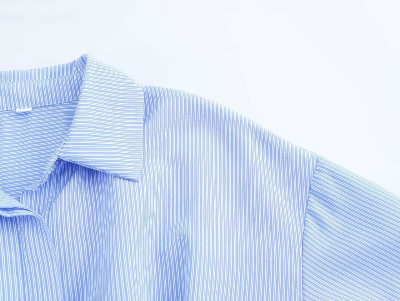 Chemisier élégant court à rayures bleu et blanc avec une ceinture à boucle effet écaille de tortue.