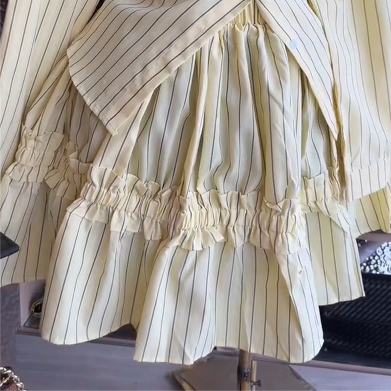 Ensemble deux pièces jaune à fines rayures se compose d'une chemise à manches longues avec un basque structuré et d'une jupe évasée à volant